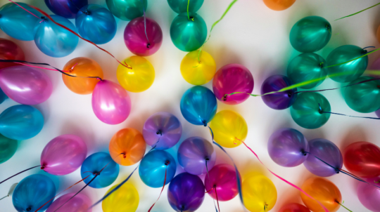 a bunch of colorful balloons are arranged in a circle