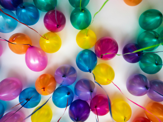 a bunch of colorful balloons are arranged in a circle