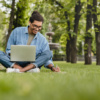 Man on his laptop in the grass
