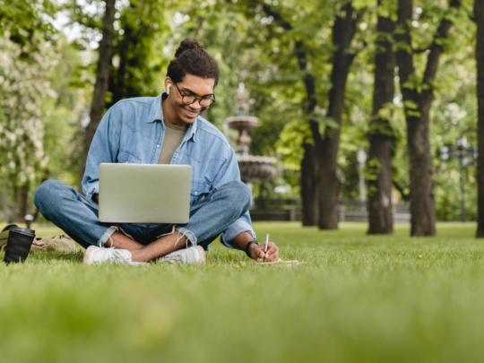 Man on his laptop in the grass