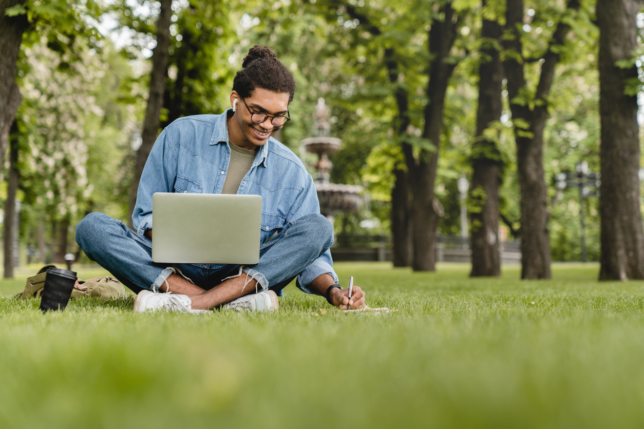 Man on his laptop in the grass