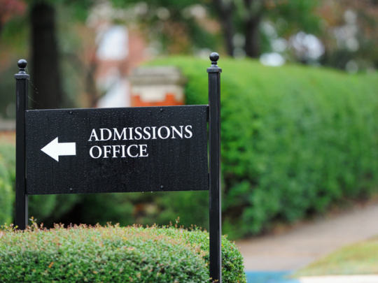 Close up of admissions office sign near public university campus
